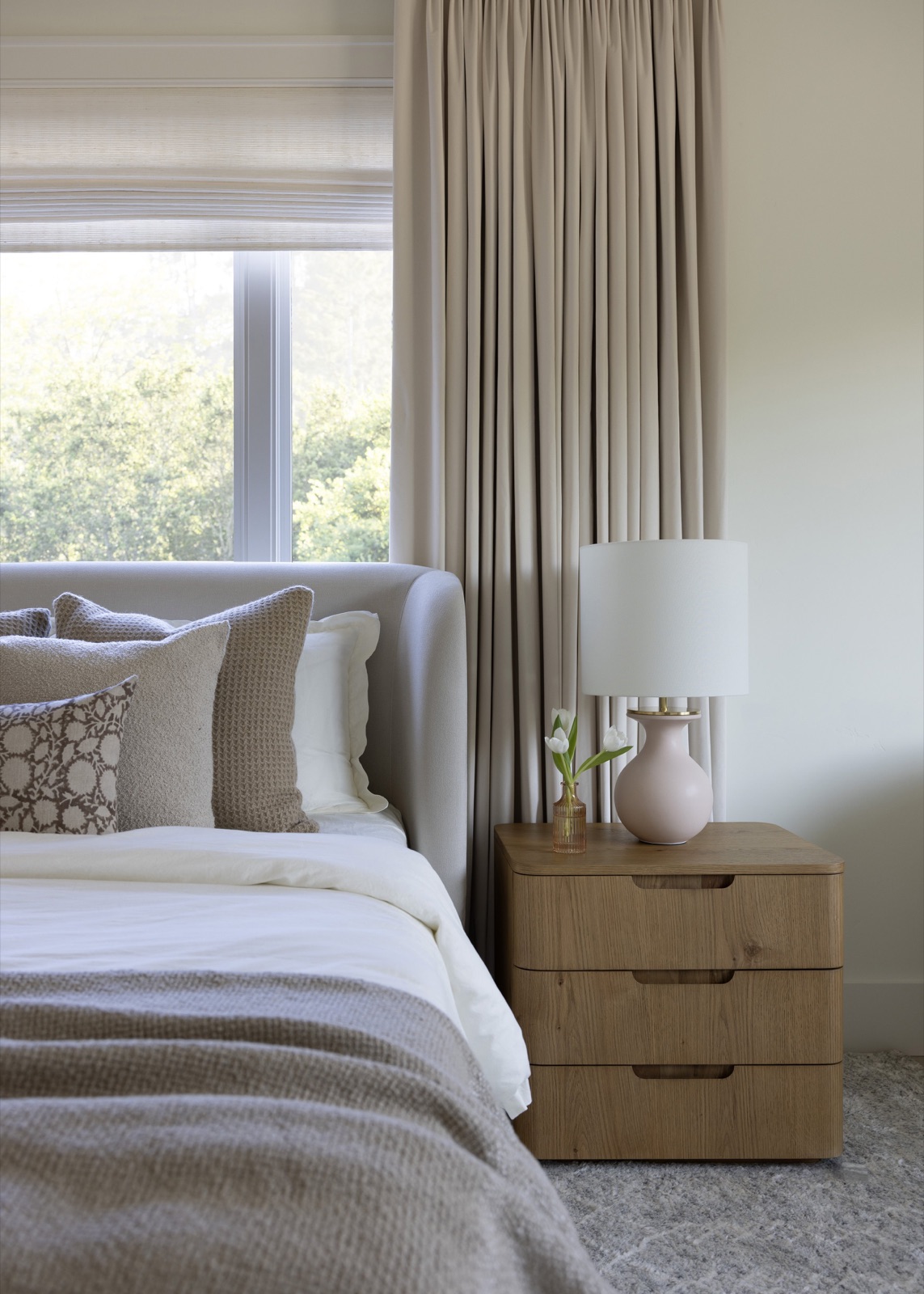 Bedroom detail, oak nightstand and soft drapery.