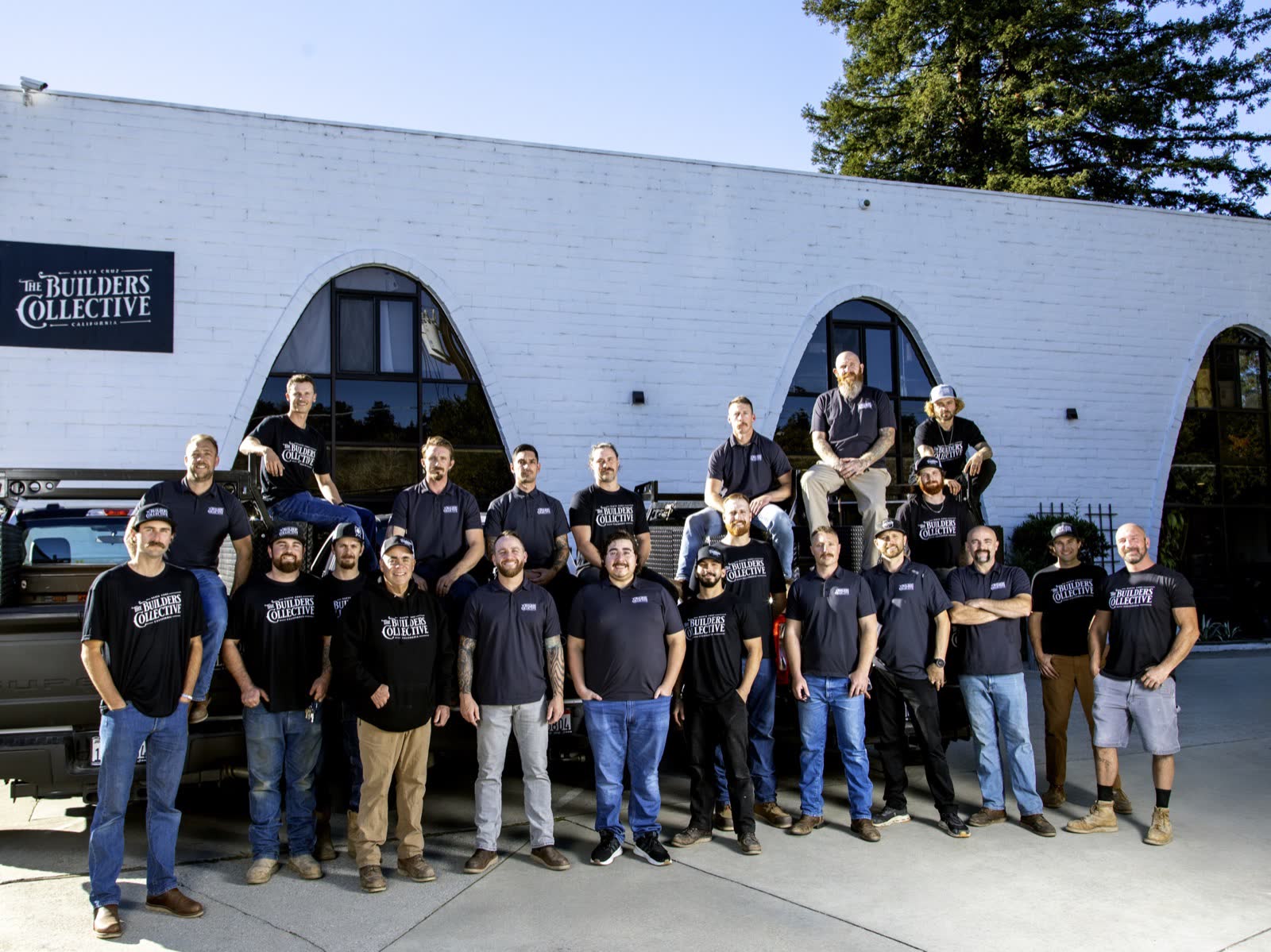 The Builders Collective team gathered in front of their Santa Cruz shop and trucks.